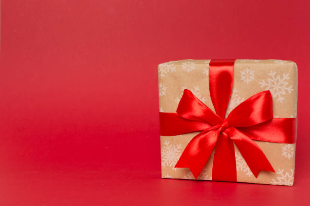 istock Gift box with red ribbon bow on color background 1617232673