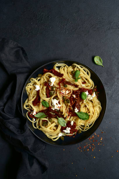 istock Pasta bavette with dried tomatoes, kapers and ricotta. Top view with copy space. 1617232688