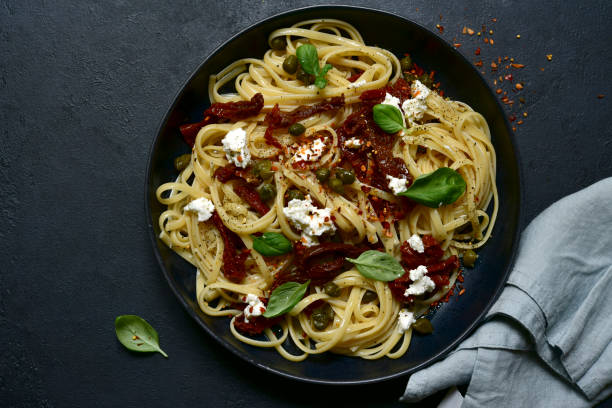istock Pasta bavette with dried tomatoes, kapers and ricotta. Top view with copy space. 1617233815