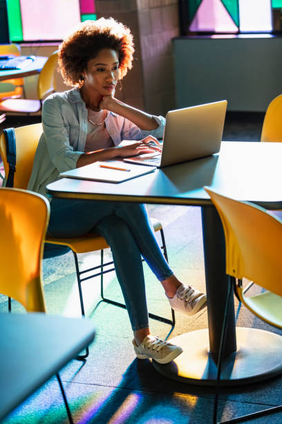istock Young African-American woman using laptop at table 1617243953