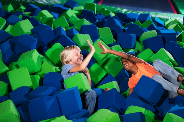 istock Two multiracial boys playing in a pool of foam blocks 1617243961