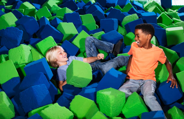 istock Two multiracial boys playing in a pool of foam blocks 1617243970