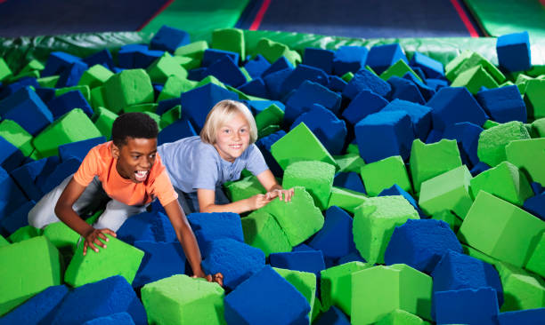 istock Two multiracial boys playing in a pool of foam blocks 1617244444