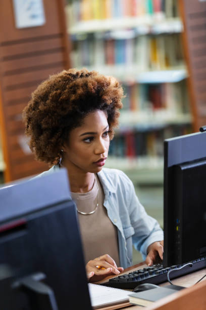 istock Young African-American woman using computer in library 1617244519
