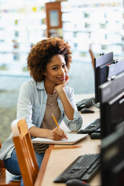 istock Young African-American woman using computer in library 1617244556