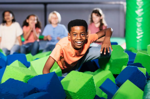 istock Boy and friends playing at indoor amusement center 1617245656