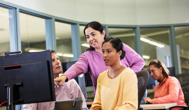 Adult Student Computer Learning 110+ Instructor Helping Diverse Group Of Mature Adults In Computer Lab ...