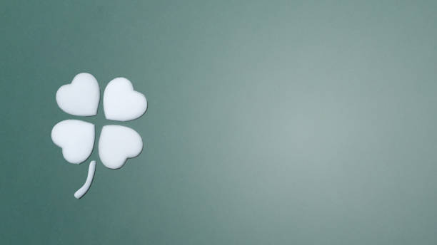 istock Four leaf clover or cloverleaf made with a white hearts on a forest green background with card note space for text or message. 1617269171