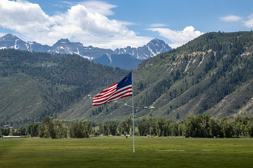 USA Flag in the mountains. Green meadow contrasting with the colors.