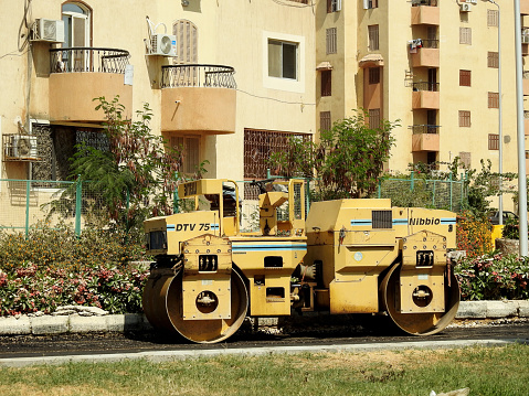 Cairo, Egypt, July 21 2023: Asphalt compactor paver truck, A paver (road paver finisher, asphalt finisher, road paving machine) is a piece of construction equipment used to lay asphalt concrete, selective focus