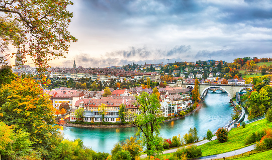 Amazing autumn view of Bern city on  Aare river during evening with Pont de Nydegg bridge and Nydeggkirche - Protestant church. Location: Bern, Canton of Bern, Switzerland, Europe