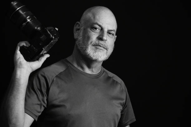 photographer portrait of man holding photo camera record of images photographer portrait of man holding photo camera record of images clicks black and white portrait photographers stock pictures, royalty-free photos & images