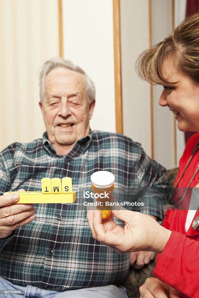 Casa Saúde enfermeira, explicando medicamentos - Foto de stock de Organizador de comprimidos royalty-free