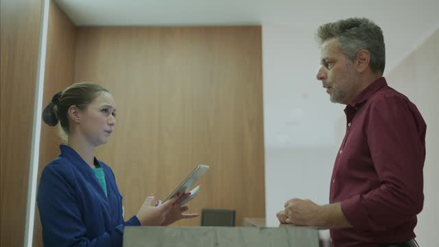Receptionist talking to a patient in a medical clinic