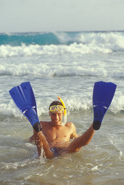 istock Young man with flippers, mask and snorkel on the beach 1617514603