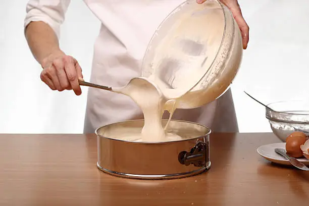 Pouring cake mix into baking tin (springform).