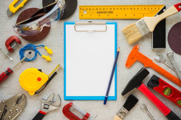 Flat lay, set of construction hardware tools building, repair, painting accessories and blank paper clipboard on concrete board background.