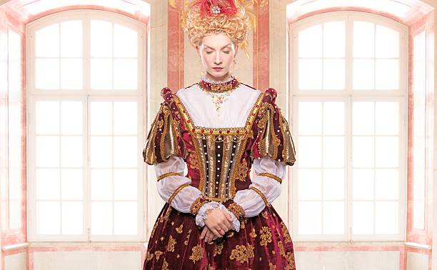 его королевское высочество стоя против окна - renaissance women queen fashion стоковые фото и изображения