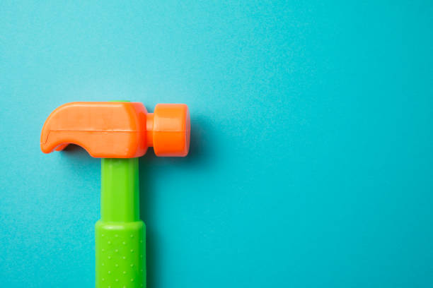 Flat lay of hammer plastic toy on blue background with copy space. Playing with toys can be an enjoyable means of training young children for life in society.