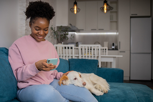 Happy young woman using her smartphone