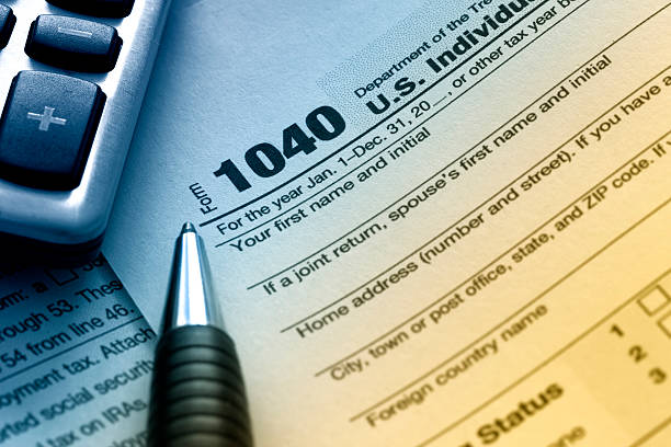 US Tax Form 1040 US tax form 1040 with pen and calculator. 1040 tax form photos stock pictures, royalty-free photos & images