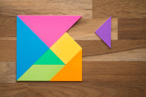 istock Flat lay of a missing piece in square tangram puzzle on wooden table background. 1617612877