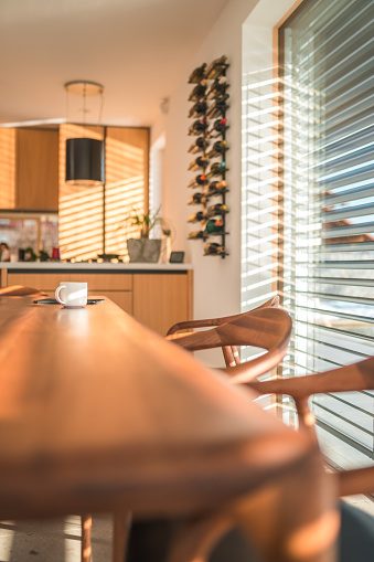 White coffee cup on a modern wooden dining table. Elegant apartment.