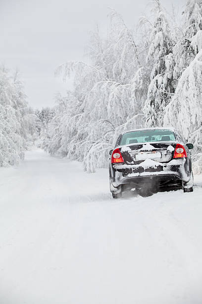 macchina nera in piedi sulla strada di inverno - rear view winter blizzard nordic countries foto e immagini stock