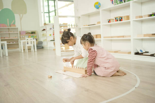 istock Mixed girls playing with knobbed cylinders 1617656588