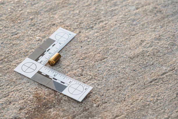 One crime scene evidence ruler on the street after a gun shooting One crime scene evidence ruler on the street after a gun shooting brass bullet shell casing 9mm handgun pistol gun laws stock pictures, royalty-free photos & images