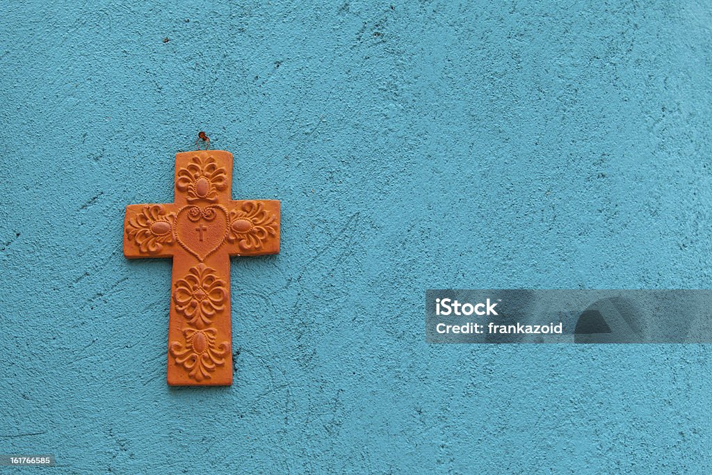 Cruz de terracota em uma parede turquesa - Foto de stock de Cruz - Objeto religioso royalty-free