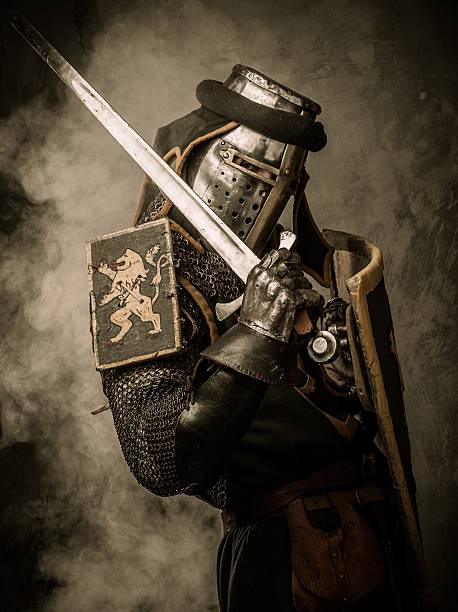 istock Medieval knight with sword and shield against stone wall 161766954