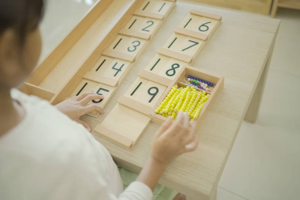 istock Elementary girl using color bead chain to learn mathematics 1617672759