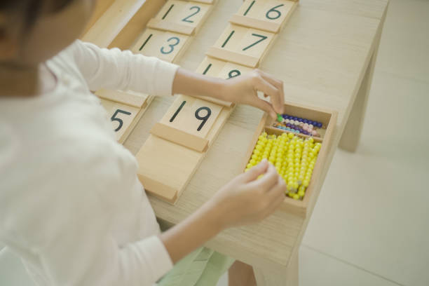 istock Elementary girl using color bead chain to learn mathematics 1617673294