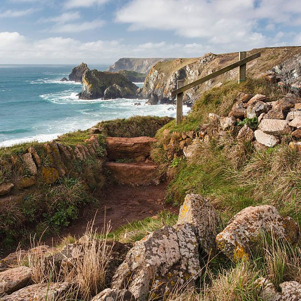 Cornish Coastpath A view of the South West Coast path towards Kynance cove on the South of England. The sea is turquoise in colour and the cliffs are sunlit. cornwall england photos stock pictures, royalty-free photos & images