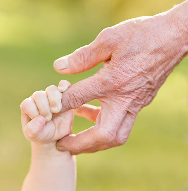 hands old man and a kid old man and a kid holding hands together old man baby stock pictures, royalty-free photos & images