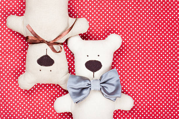 Toy bears couple on red cotton background