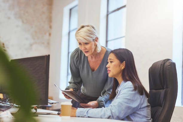 istock Manager and colleague reading business plan on computer in office 1617695748