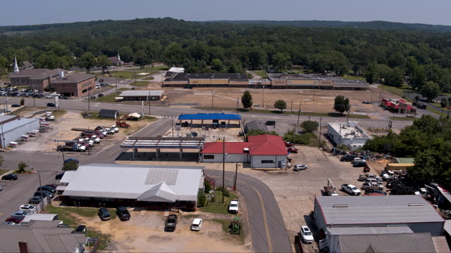 Gas station and abandoned mall in Hamilton - a small city in Alabama, on a sunny summer day. Drone aerial footage with forwarding camera motion.