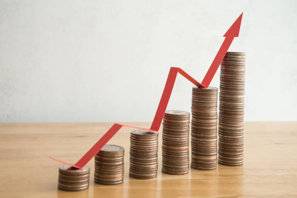 istock Stack of coins bar chart and red arrow growth chart with white wall background. 1617702502