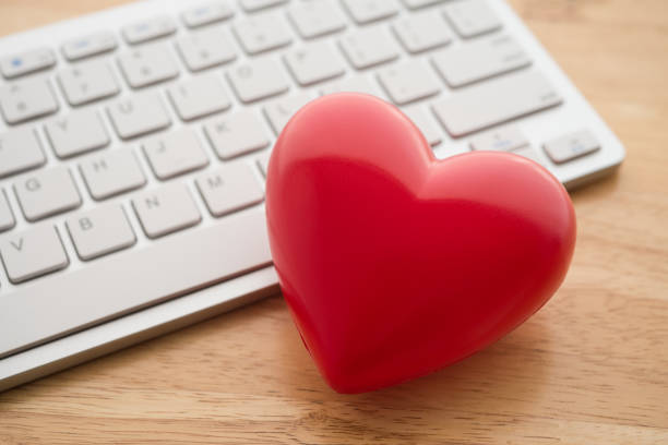 istock Cute red heart with white keyboard on wooden table background. 1617703558