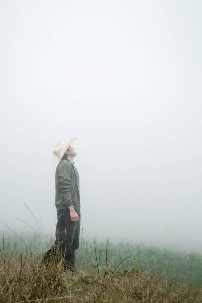 cowboy delight - mężczyzna w meksykańskim kapeluszu i butach pośród mglistego krajobrazu - grass area flash zdjęcia i obrazy z banku zdjęć