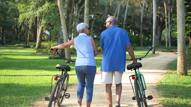 Senior African American couple walking with bikes