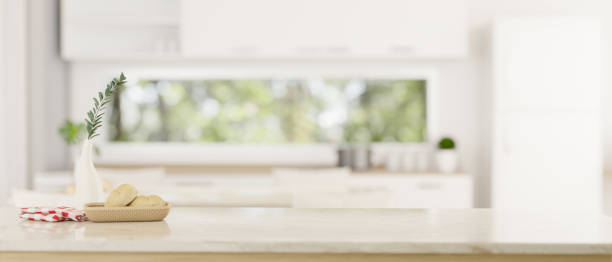 istock Copy space on a white tabletop over a blurred modern white kitchen in the background. 1617778235