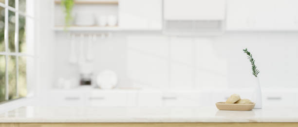 istock Copy space on a white tabletop over a blurred modern white kitchen in the background. 1617778238