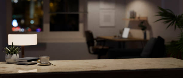 istock Copy space on a marble tabletop in a modern home office room at night. 1617778264