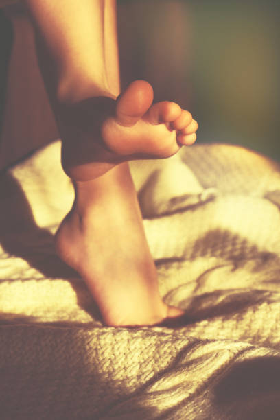 朝、家で素足で接写する。自宅でリラックスして、楽しんで、健康。快適な美学スタイル、柔らかいニットブランケット - barefoot behavior toned image close up ストックフォトと画像