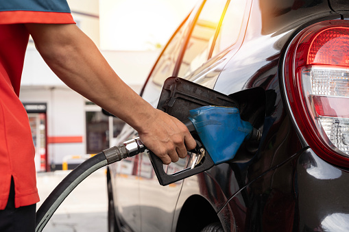 Car refueling on petrol station. Fuel pump at station. Refueling the car at a gas station fuel pump. Man driver hand refilling and pumping gasoline oil the car with fuel at he refuel station.
