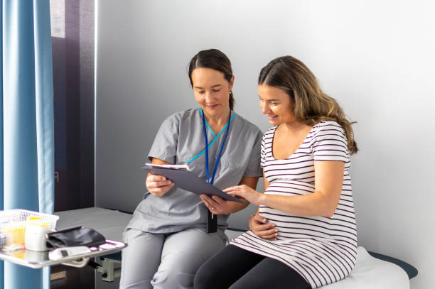 pregnant woman receives guidance on test results from nurse - human pregnancy midwife healthcare and medicine visit imagens e fotografias de stock