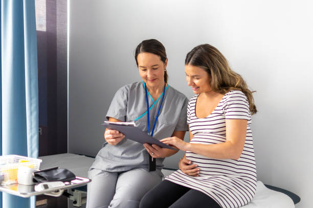 expectant mother consults test findings with compassionate nurse - human pregnancy midwife healthcare and medicine visit imagens e fotografias de stock